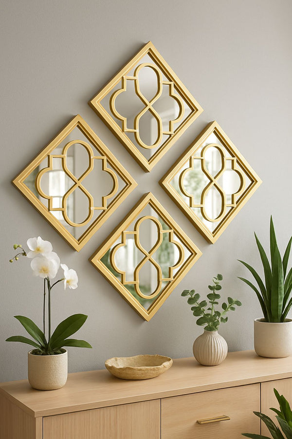 Set of four gold decorative mirrors on a wall with plants on a wooden cabinet.